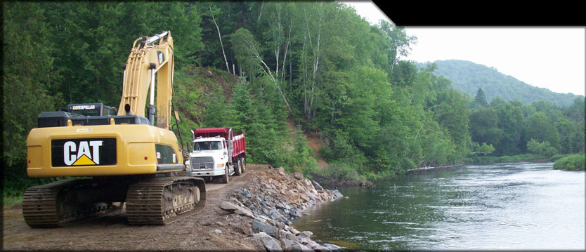 excavatrice et camion sur le bord d'un lac